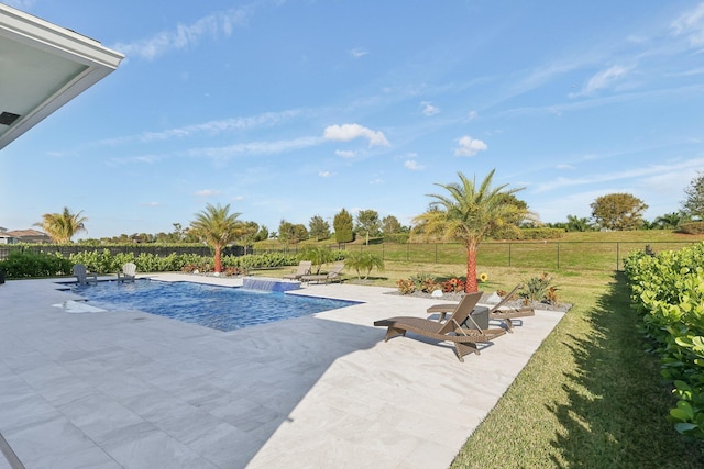 view of pool featuring pool water feature, a lawn, a patio area, and a rural view