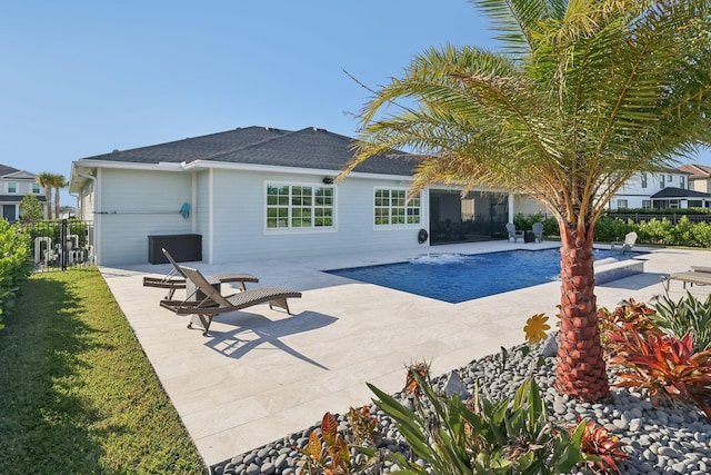 back of property with a fenced in pool and a patio area