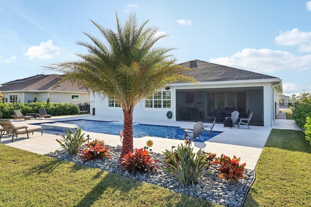 view of pool featuring a yard, a sunroom, a patio, and a jacuzzi