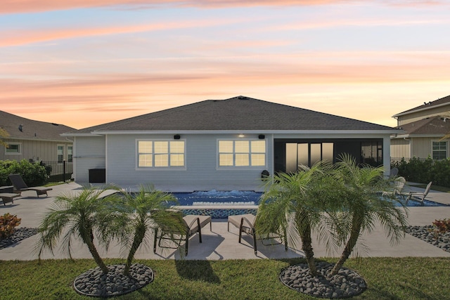 back house at dusk featuring a patio