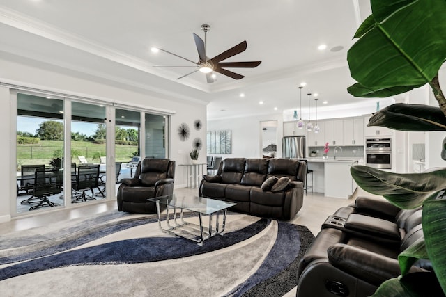 living room featuring sink, crown molding, and ceiling fan