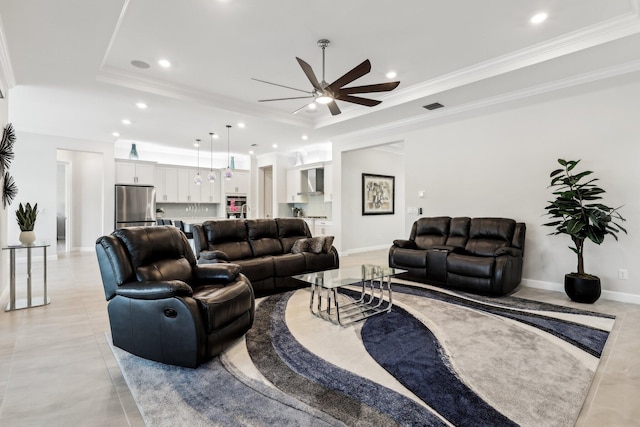 living room with crown molding, ceiling fan, and a tray ceiling