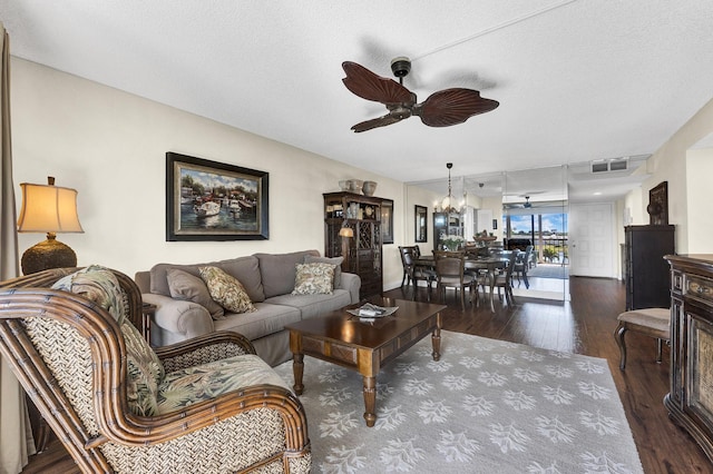 living room with ceiling fan with notable chandelier, hardwood / wood-style floors, and a textured ceiling