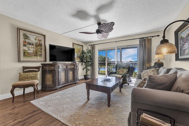 living room with hardwood / wood-style floors, a textured ceiling, and ceiling fan