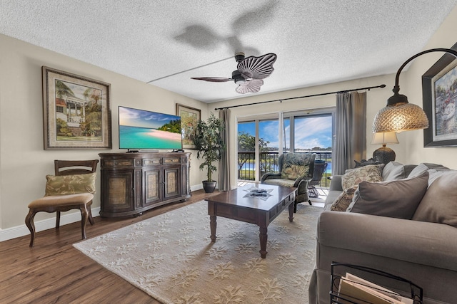 living room with ceiling fan, hardwood / wood-style floors, and a textured ceiling