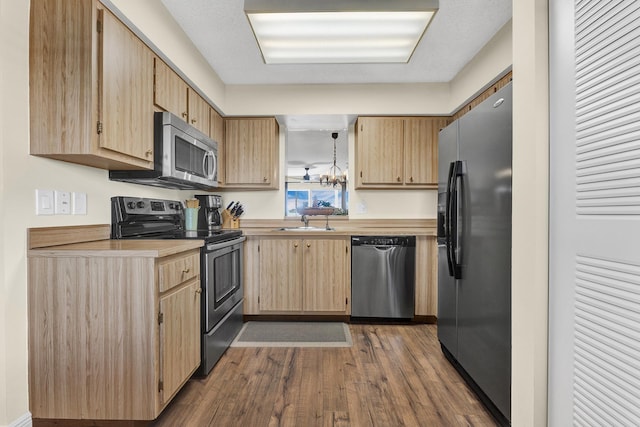 kitchen with pendant lighting, sink, dark wood-type flooring, stainless steel appliances, and light brown cabinetry