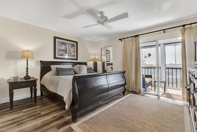 bedroom featuring dark hardwood / wood-style flooring, ceiling fan, access to outside, and a textured ceiling