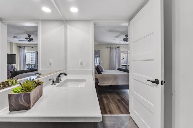 bathroom with vanity, hardwood / wood-style floors, a textured ceiling, and ceiling fan