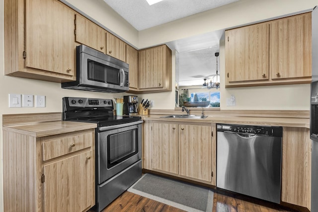 kitchen featuring sink, a textured ceiling, light brown cabinets, appliances with stainless steel finishes, and dark hardwood / wood-style flooring