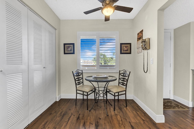 dining space with dark wood-type flooring, ceiling fan, and a textured ceiling