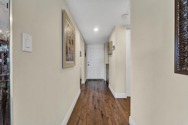 hallway with dark hardwood / wood-style flooring and a textured ceiling