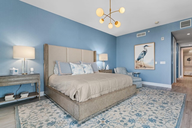 bedroom featuring hardwood / wood-style flooring and an inviting chandelier