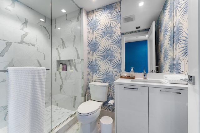 bathroom with vanity, toilet, and a tile shower