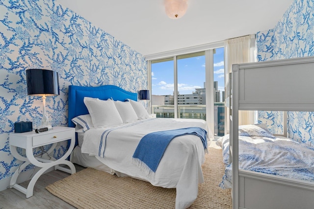 bedroom featuring wood-type flooring and floor to ceiling windows