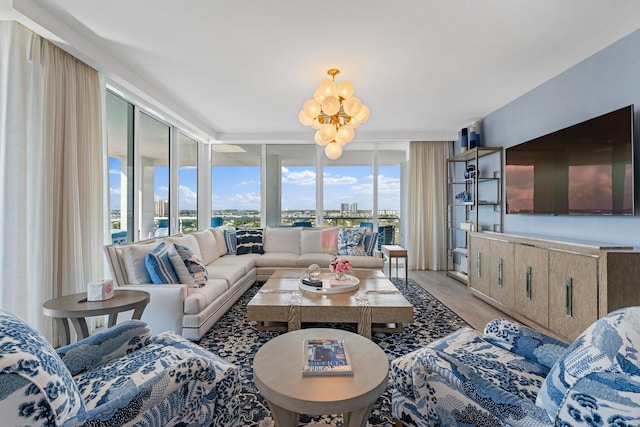 living room with floor to ceiling windows, a notable chandelier, and light hardwood / wood-style flooring