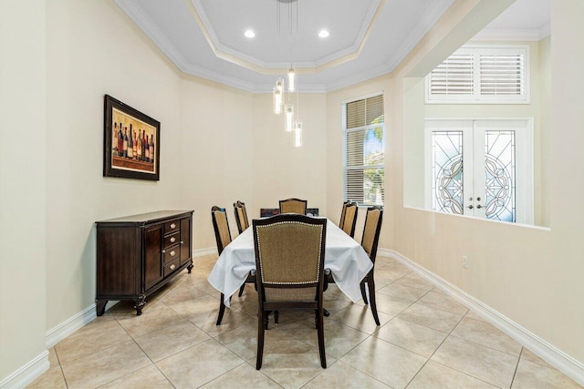 dining room featuring ornamental molding, a tray ceiling, and light tile patterned floors