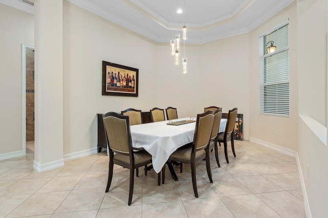 tiled dining space with ornamental molding and a raised ceiling