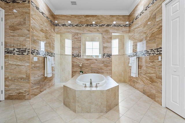 bathroom featuring a relaxing tiled tub, ornamental molding, tile patterned flooring, and tile walls