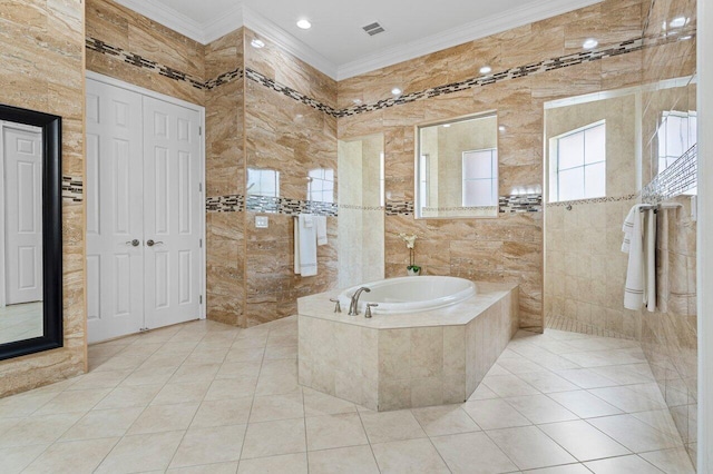 bathroom featuring tile walls, tiled tub, crown molding, and tile patterned floors