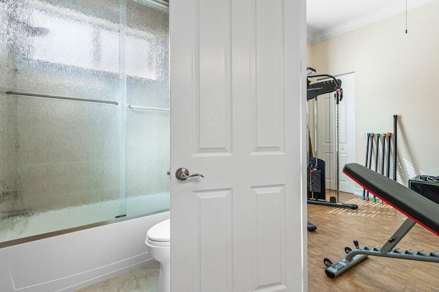 bathroom with crown molding, shower / bath combination with glass door, toilet, and hardwood / wood-style flooring