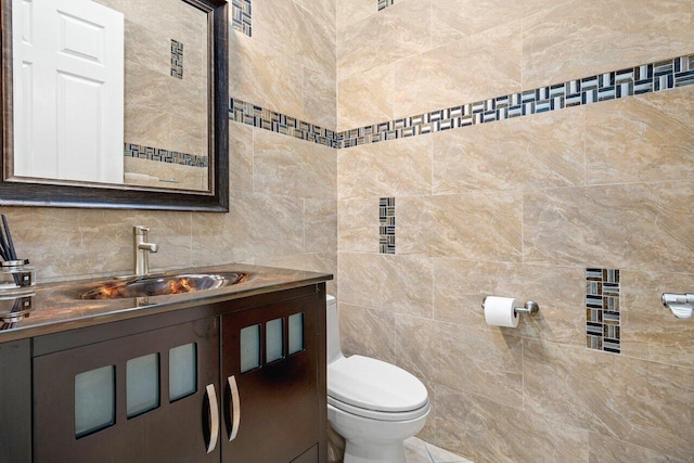 bathroom featuring tasteful backsplash, vanity, toilet, and tile walls