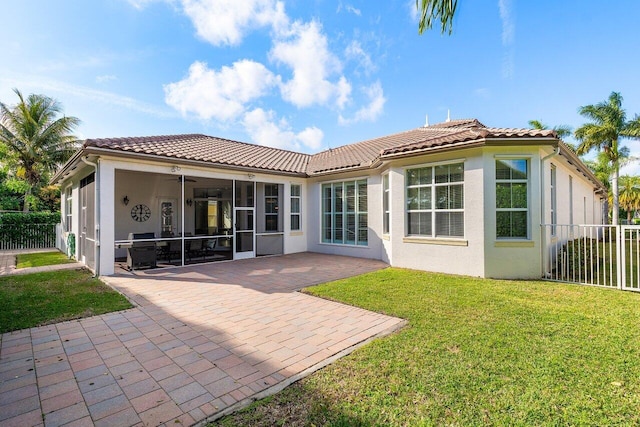 rear view of house featuring a yard, a patio area, a sunroom, and ceiling fan