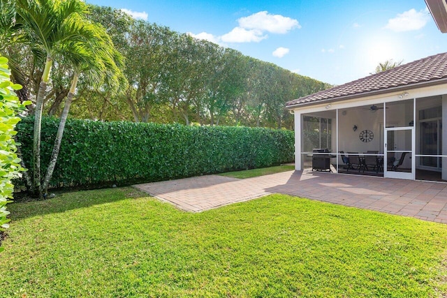 view of yard featuring a mountain view, a sunroom, a patio, and ceiling fan