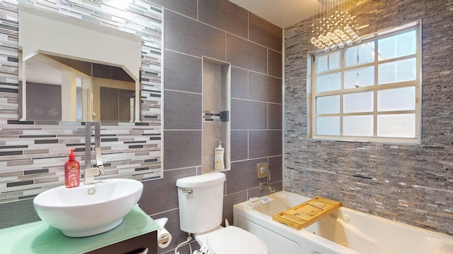 bathroom with a tub to relax in, backsplash, a wealth of natural light, and toilet