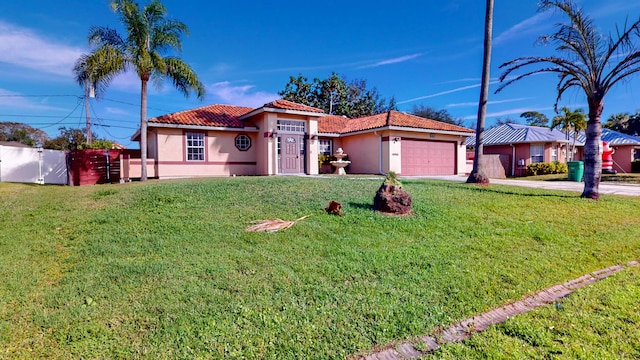 mediterranean / spanish home with a garage and a front lawn