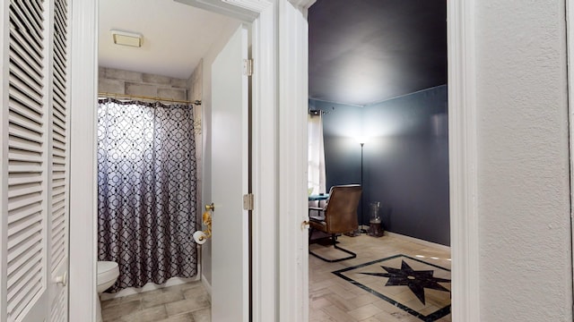 bathroom featuring a shower with curtain, parquet floors, and toilet