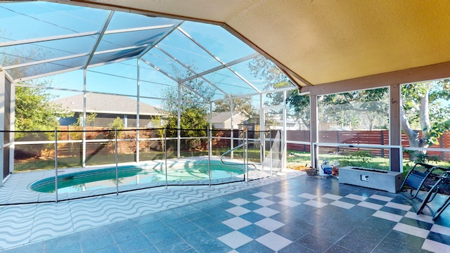 view of pool with glass enclosure and a patio area