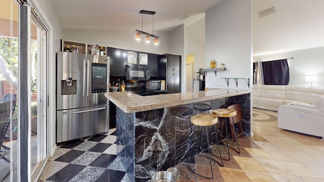 kitchen with a breakfast bar, hanging light fixtures, high vaulted ceiling, light stone counters, and black appliances