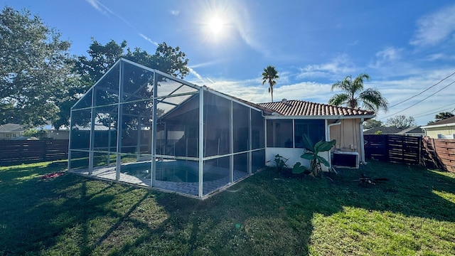 rear view of property featuring a fenced in pool, a yard, central air condition unit, and a lanai