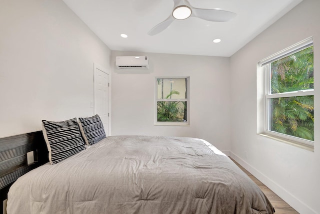 unfurnished bedroom with baseboards, recessed lighting, wood finished floors, a wall mounted AC, and a ceiling fan