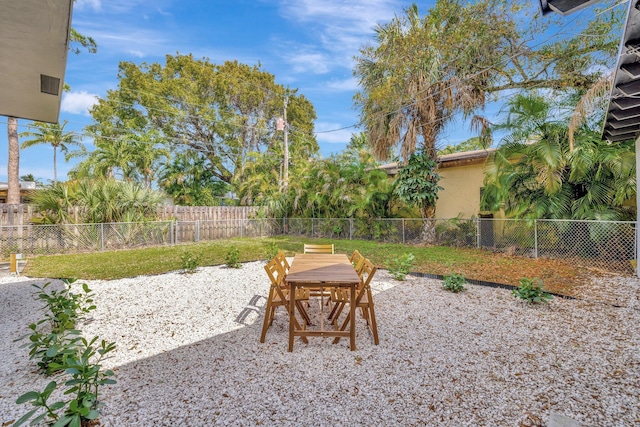 view of yard featuring a patio area, outdoor dining area, and a fenced backyard