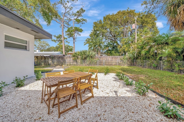 view of yard featuring outdoor dining area, a patio, and a fenced backyard