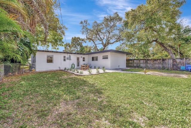 back of house featuring stucco siding, a yard, a fenced backyard, and a patio area