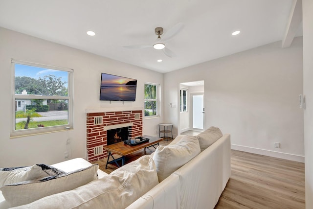 living room with light wood-style floors, baseboards, a wealth of natural light, and ceiling fan