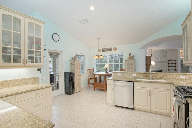 kitchen with lofted ceiling, light tile patterned floors, sink, stainless steel appliances, and cream cabinets