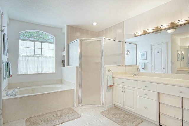 bathroom with vanity, tile patterned flooring, plus walk in shower, and a textured ceiling