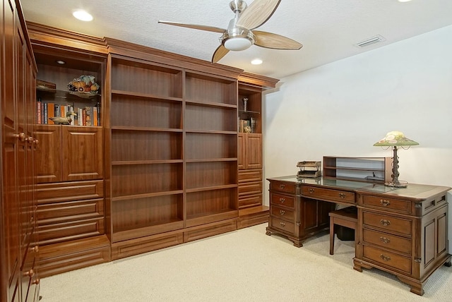 office space featuring light carpet, a textured ceiling, and ceiling fan