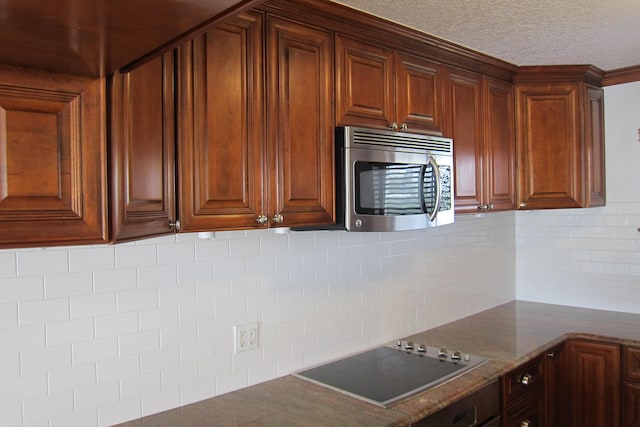 kitchen featuring black electric stovetop, decorative backsplash, a textured ceiling, and stone countertops