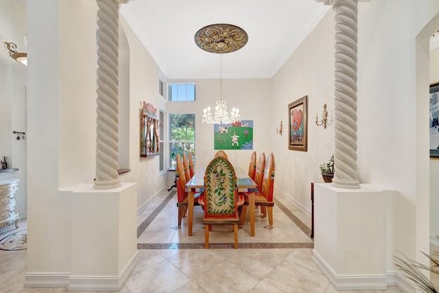 dining space featuring ornamental molding, a chandelier, and ornate columns