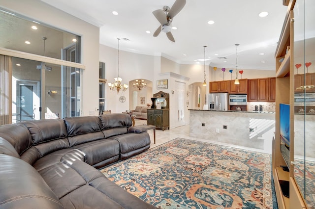 living room with crown molding, ceiling fan with notable chandelier, and high vaulted ceiling