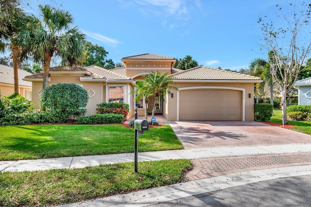 mediterranean / spanish home with a garage and a front lawn