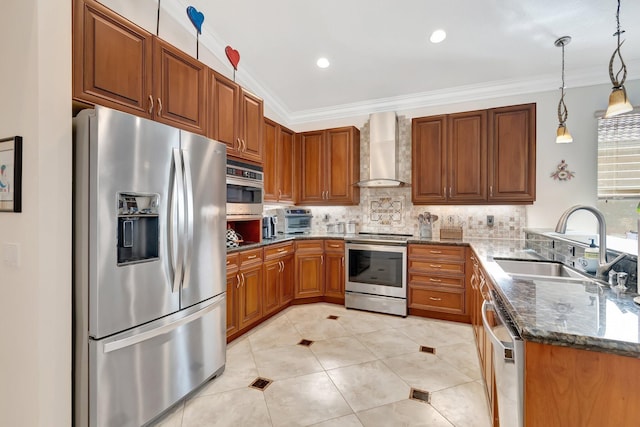 kitchen with sink, hanging light fixtures, dark stone countertops, stainless steel appliances, and wall chimney range hood