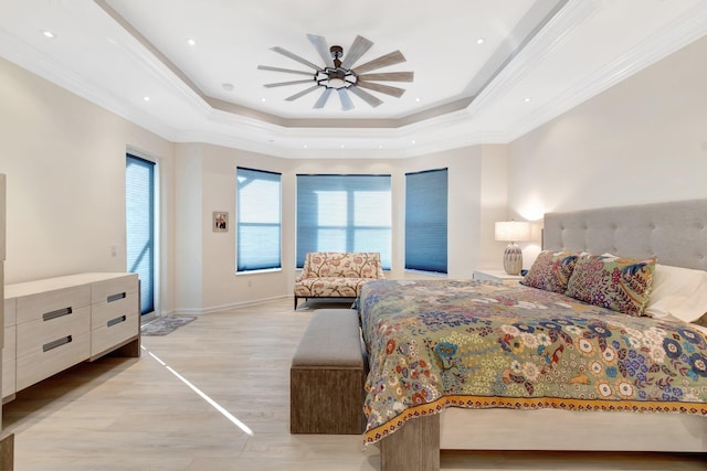 bedroom with ceiling fan, ornamental molding, a raised ceiling, and light hardwood / wood-style flooring