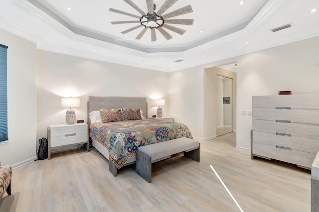 bedroom featuring crown molding, ceiling fan, a raised ceiling, and light wood-type flooring