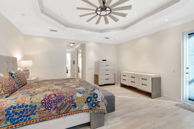 bedroom featuring crown molding, a tray ceiling, light hardwood / wood-style flooring, and ceiling fan