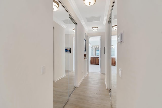 corridor with ornamental molding and light wood-type flooring